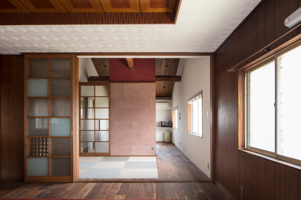 Cette image montre un salon traditionnel avec un mur beige, parquet foncé, un sol marron et un plafond en bois.