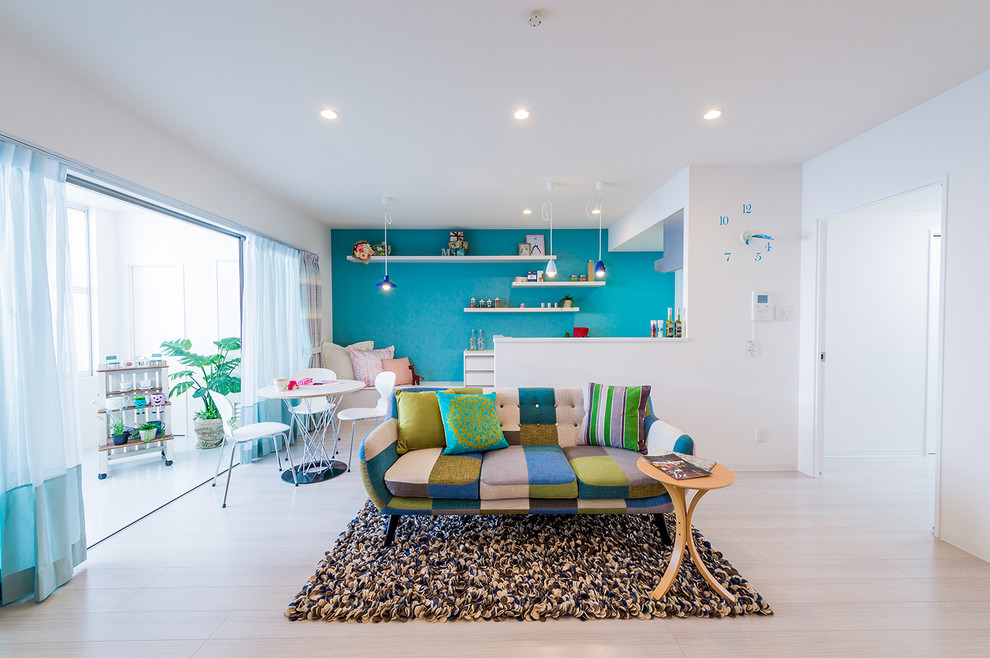 Réalisation d'un salon bohème ouvert avec un mur blanc et parquet peint.