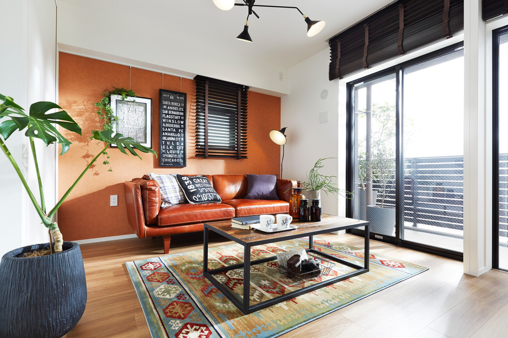 Foto de salón de estilo zen sin chimenea y televisor con parades naranjas y suelo de madera en tonos medios