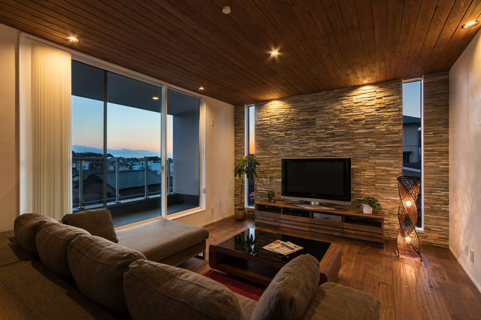 Esempio di un soggiorno minimalista con pareti multicolore, parquet scuro, TV autoportante e pavimento marrone