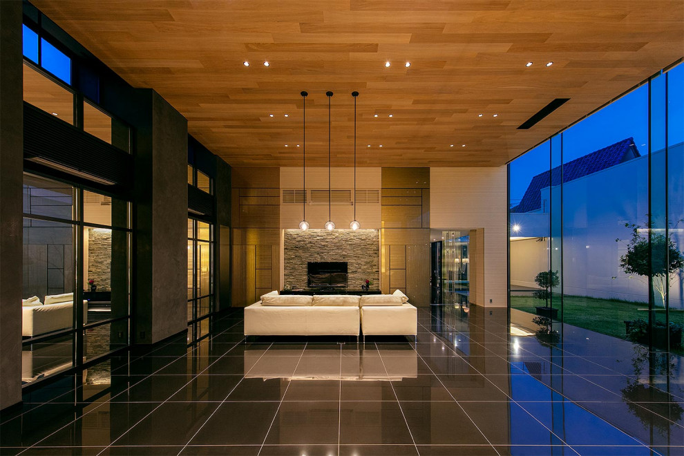 Пример оригинального дизайна: парадная, открытая гостиная комната в стиле модернизм с бежевыми стенами, отдельно стоящим телевизором, черным полом и обоями на стенах без камина