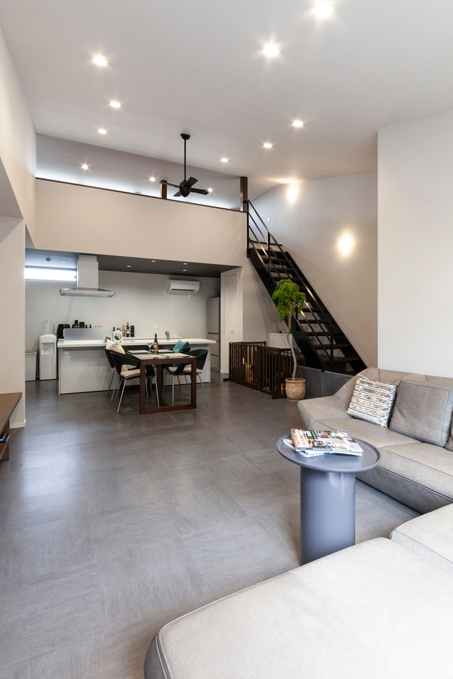 Immagine di un soggiorno minimalista aperto con pareti bianche e pavimento grigio