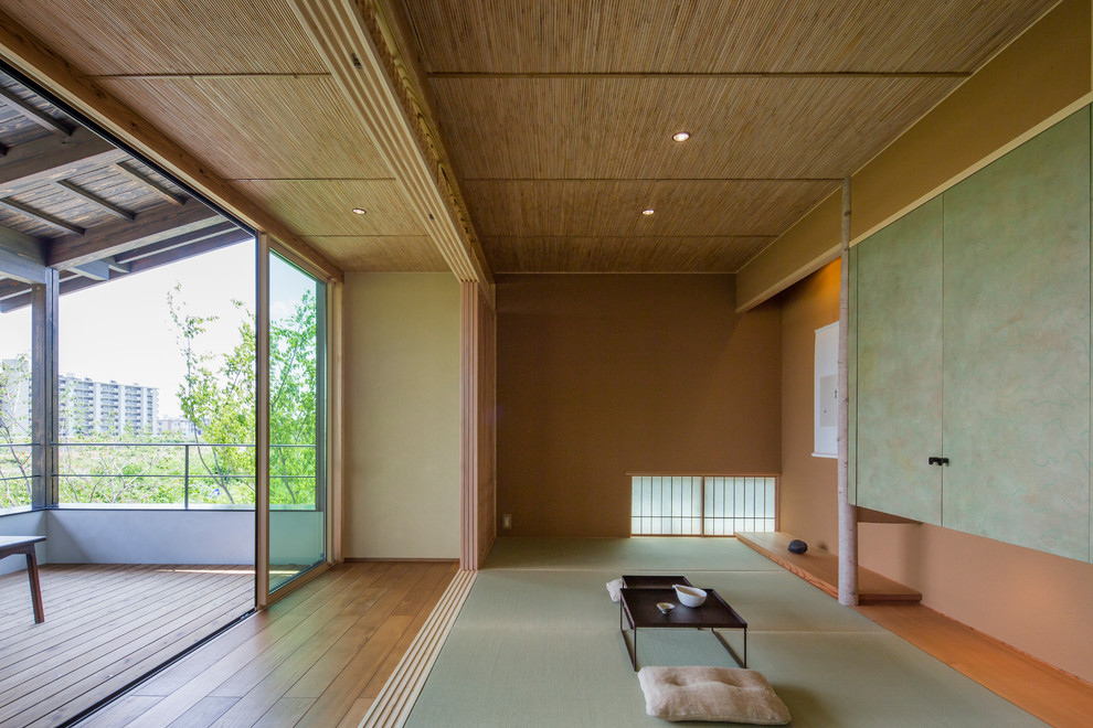Repräsentatives, Offenes Asiatisches Wohnzimmer mit brauner Wandfarbe, Tatami-Boden und grünem Boden in Nagoya