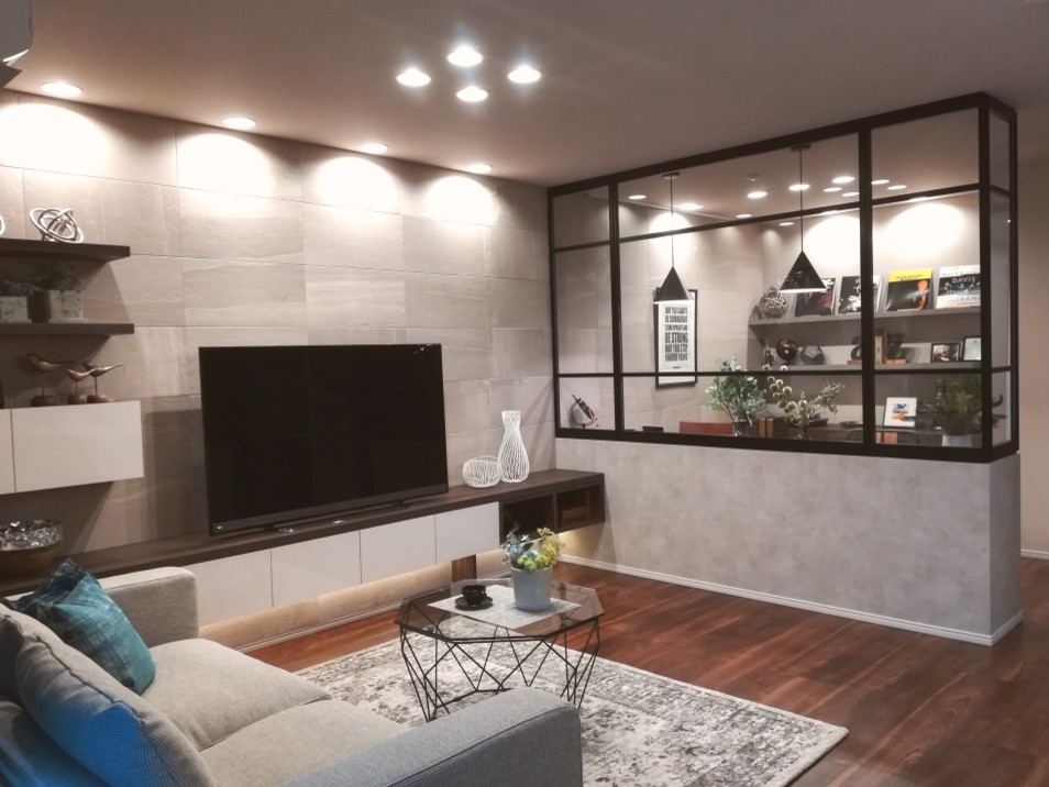 На фото: открытая гостиная комната в стиле лофт с серыми стенами, полом из фанеры, отдельно стоящим телевизором, коричневым полом и музыкальной комнатой без камина