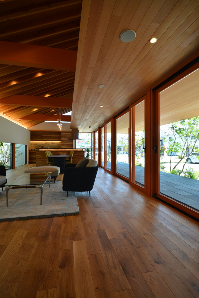 Diseño de salón abierto contemporáneo sin chimenea con paredes blancas, suelo de madera en tonos medios y suelo beige