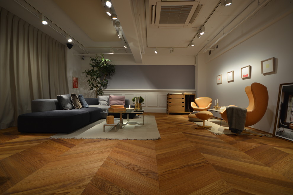 Modelo de salón para visitas abierto escandinavo sin chimenea y televisor con paredes grises, suelo de madera en tonos medios y suelo beige