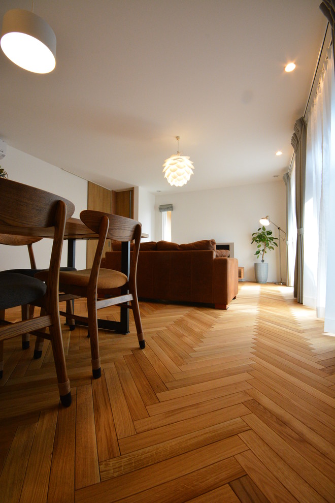 Offenes Skandinavisches Wohnzimmer ohne Kamin mit weißer Wandfarbe, braunem Holzboden und beigem Boden in Sonstige