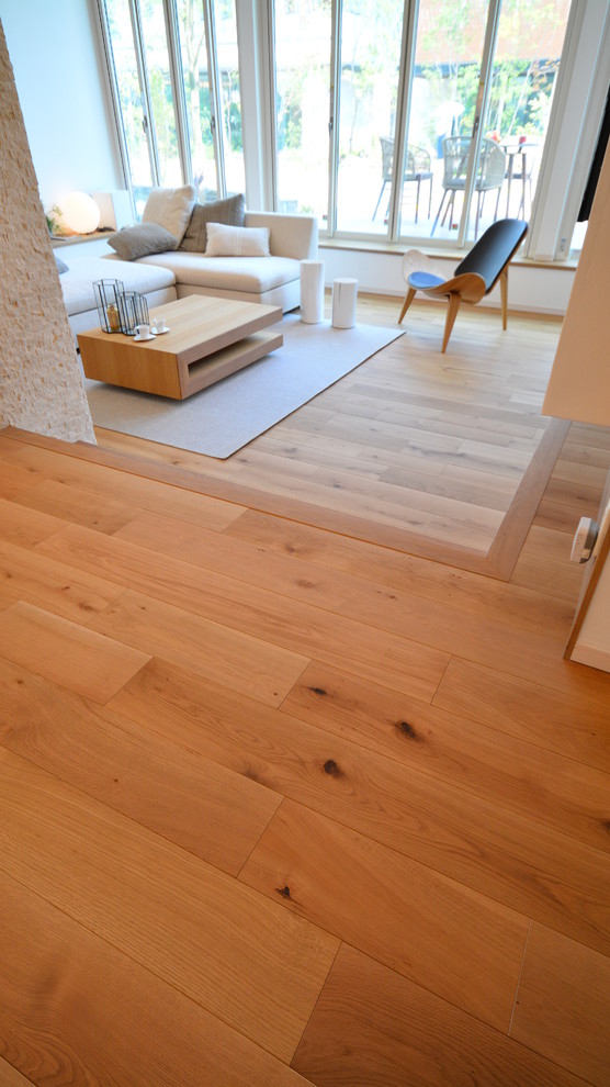 Imagen de salón abierto nórdico sin chimenea y televisor con paredes blancas, suelo de madera en tonos medios y suelo beige