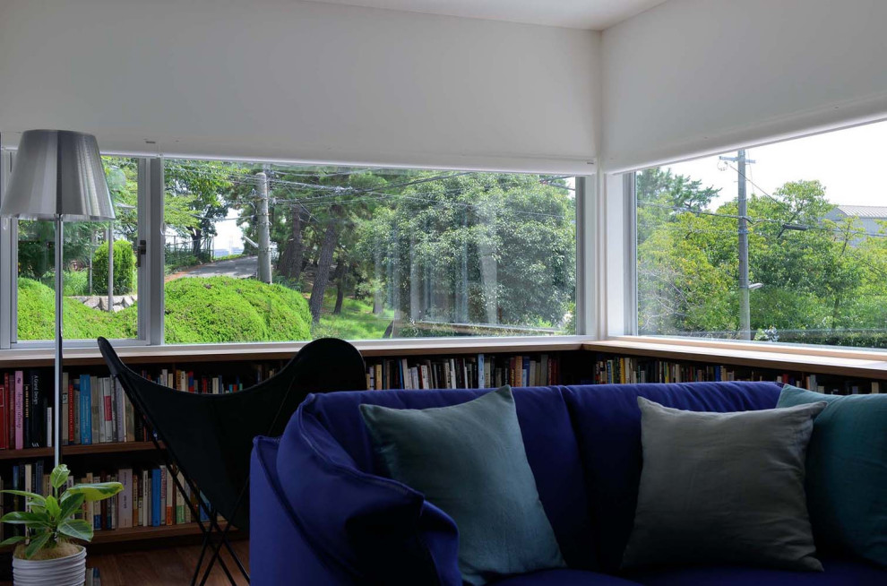 Kleine, Offene Moderne Bibliothek mit weißer Wandfarbe, Sperrholzboden, freistehendem TV, braunem Boden, Tapetendecke und Tapetenwänden in Sonstige