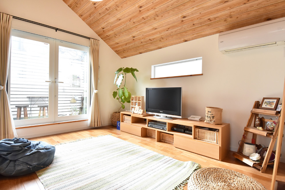 Landhaus Wohnzimmer mit weißer Wandfarbe, braunem Holzboden, freistehendem TV und braunem Boden in Tokio Peripherie