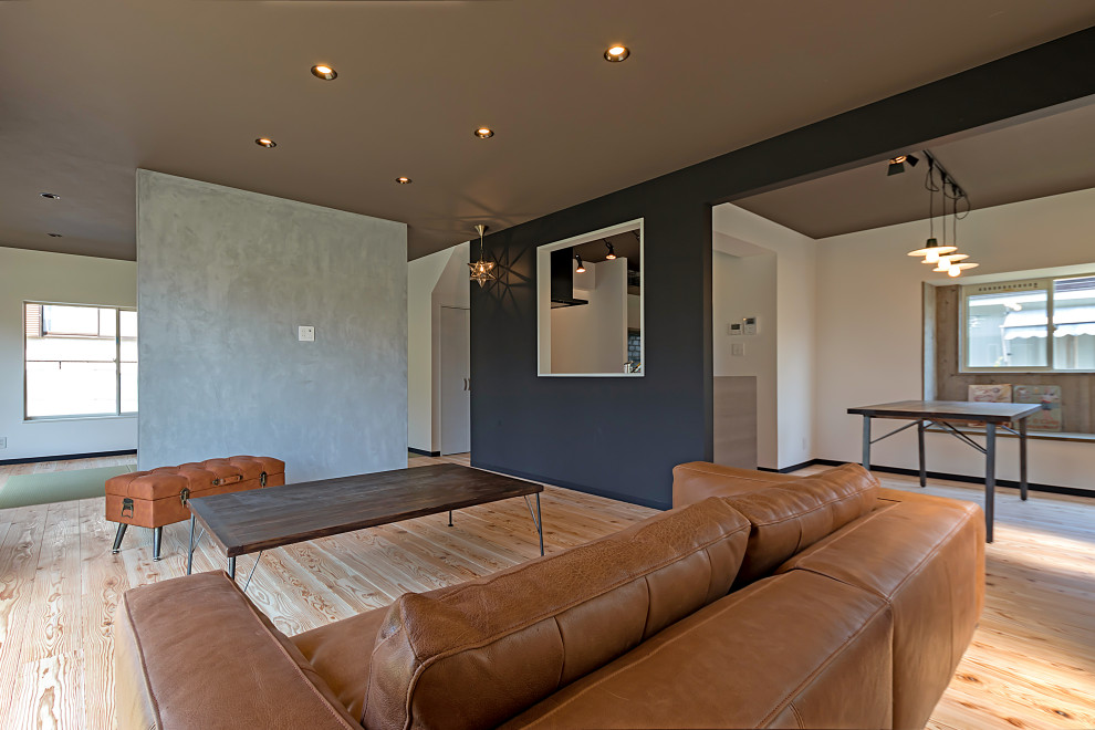 На фото: открытая гостиная комната в стиле лофт с светлым паркетным полом, потолком с обоями и обоями на стенах без телевизора