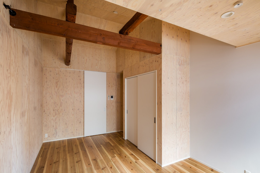 Exemple d'un salon scandinave en bois de taille moyenne et ouvert avec un mur marron, un sol en bois brun, un sol marron et poutres apparentes.