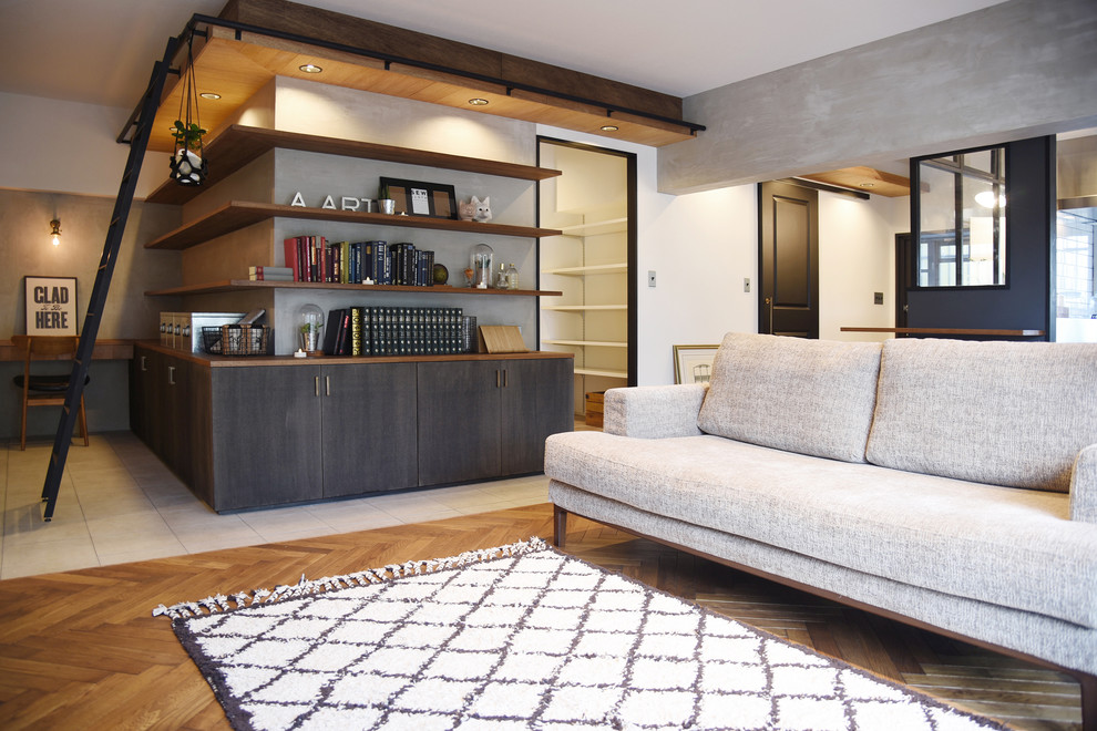 Offenes Industrial Wohnzimmer mit grauer Wandfarbe, braunem Holzboden und braunem Boden in Fukuoka