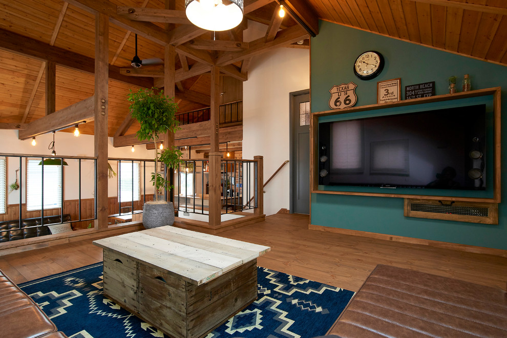 Ejemplo de salón de estilo de casa de campo con paredes multicolor, suelo de madera en tonos medios, televisor colgado en la pared y suelo marrón