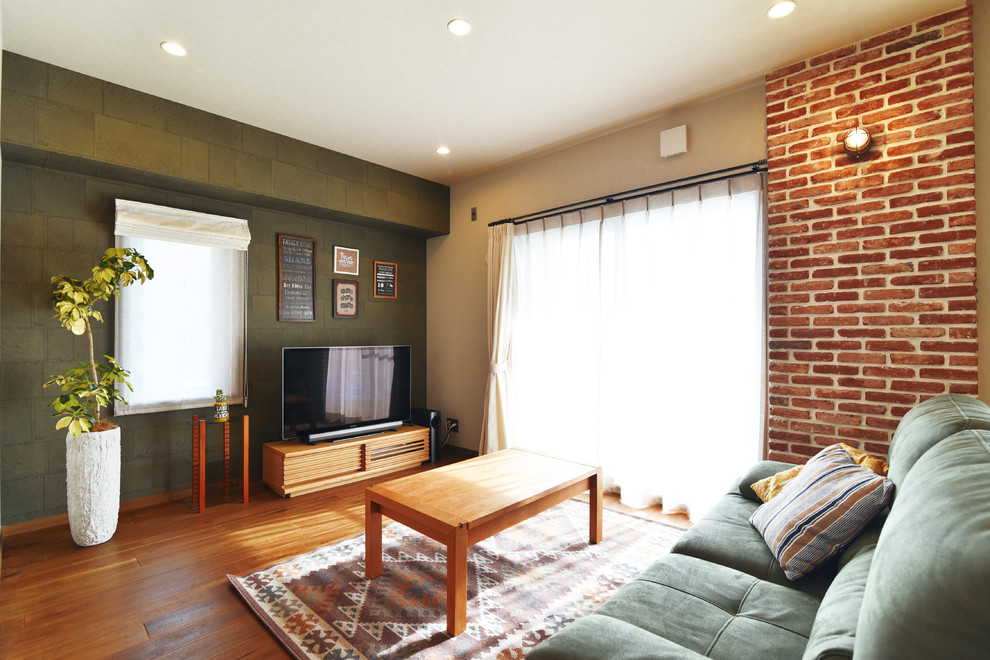 Ispirazione per un soggiorno contemporaneo con pareti verdi, pavimento in legno massello medio, TV autoportante e pavimento marrone