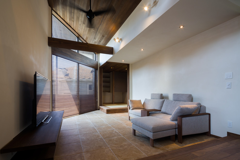 Ispirazione per un soggiorno moderno con pareti bianche, pavimento in terracotta, TV autoportante e pavimento marrone