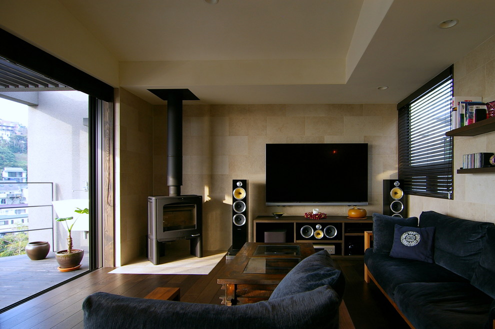 Imagen de salón minimalista con paredes beige, suelo de madera oscura, televisor colgado en la pared y suelo marrón