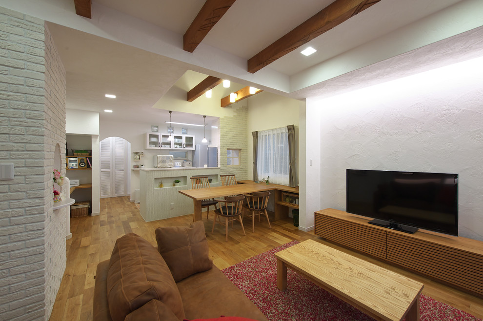 Ejemplo de salón abierto de estilo de casa de campo sin chimenea con paredes blancas, suelo de madera en tonos medios, televisor independiente y suelo marrón