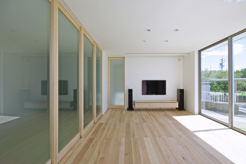 Ispirazione per un soggiorno minimalista aperto con sala della musica, pareti bianche, pavimento in compensato, nessun camino, TV a parete e pavimento beige