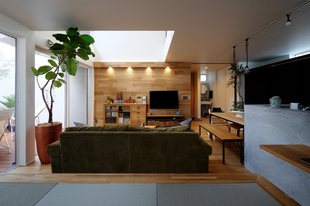 Immagine di un soggiorno moderno aperto con pavimento in legno massello medio, nessun camino, TV a parete e pavimento marrone