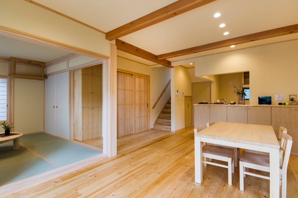 Imagen de salón abierto de estilo zen con paredes blancas, suelo de madera en tonos medios y suelo marrón