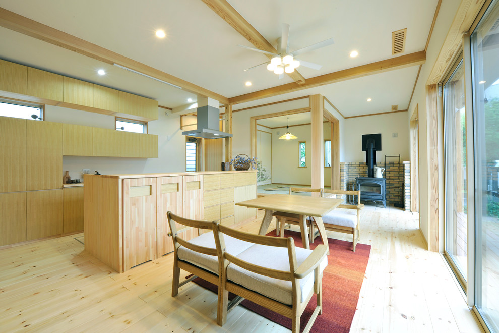 Diseño de salón abierto asiático con paredes blancas, suelo de madera clara y suelo beige