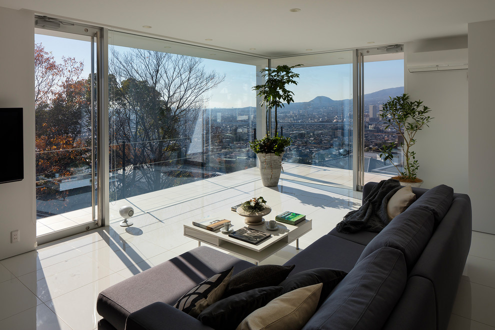 Esempio di un soggiorno minimal aperto con pareti bianche, pavimento con piastrelle in ceramica e TV a parete