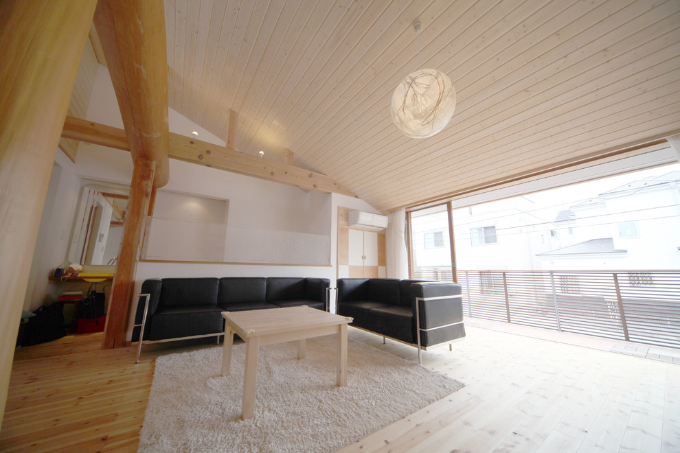 Inredning av ett minimalistiskt mellanstort allrum med öppen planlösning, med ljust trägolv, en fristående TV och beiget golv