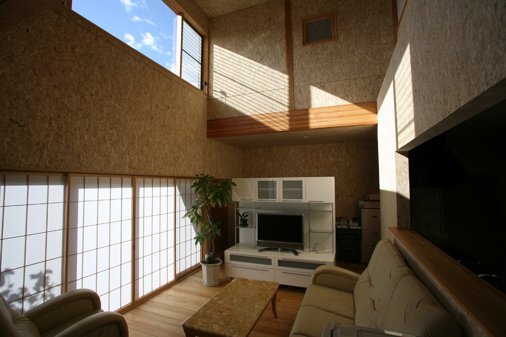 Ejemplo de salón abierto asiático de tamaño medio con paredes beige, suelo de madera clara, televisor independiente y suelo beige