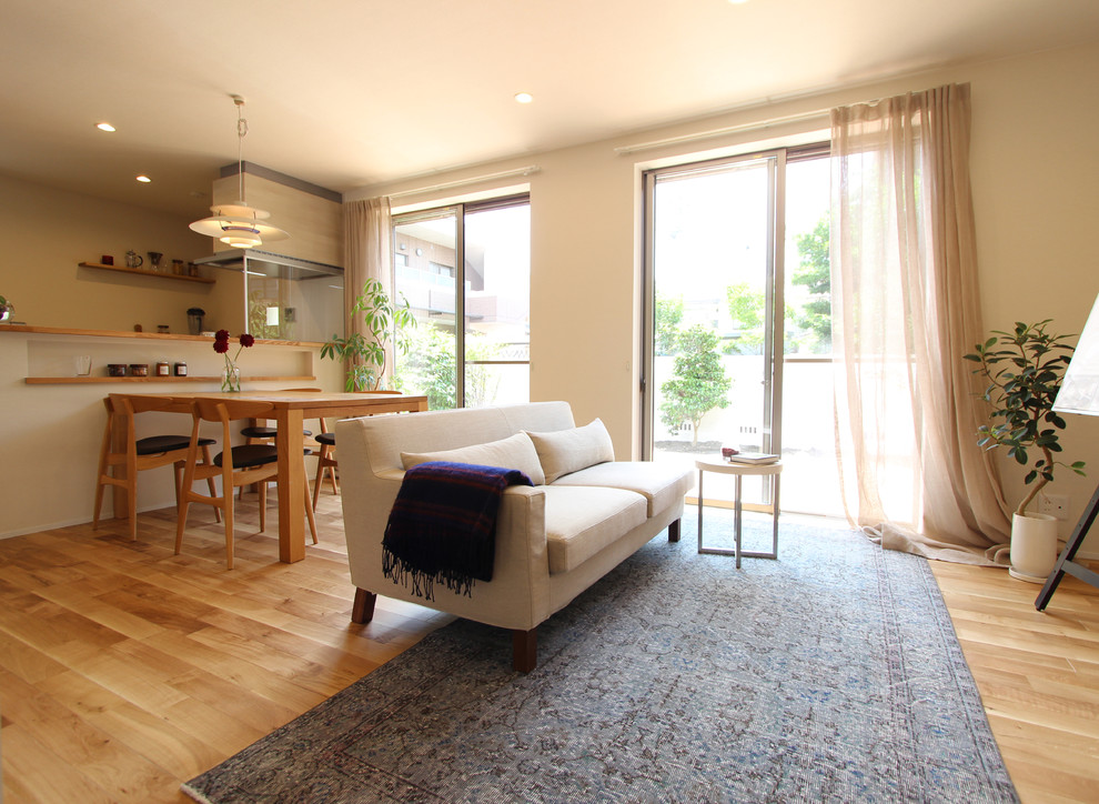 Offenes Modernes Wohnzimmer mit weißer Wandfarbe, braunem Holzboden und braunem Boden in Nagoya