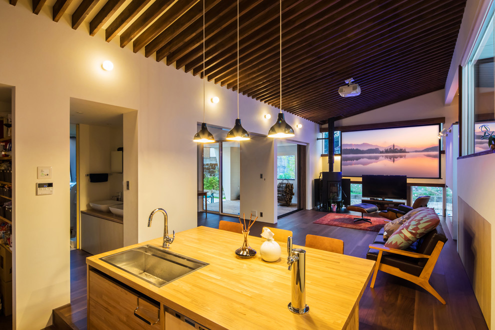 Свежая идея для дизайна: открытая гостиная комната в современном стиле с печью-буржуйкой и отдельно стоящим телевизором - отличное фото интерьера