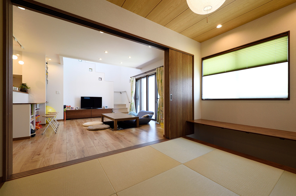 Exempel på ett mellanstort asiatiskt allrum med öppen planlösning, med vita väggar, tatamigolv och brunt golv