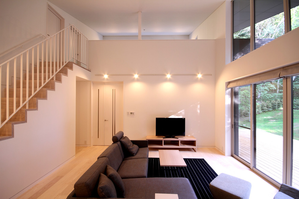 Exempel på ett mellanstort modernt separat vardagsrum, med vita väggar, målat trägolv, en dubbelsidig öppen spis, en spiselkrans i sten, en fristående TV och beiget golv