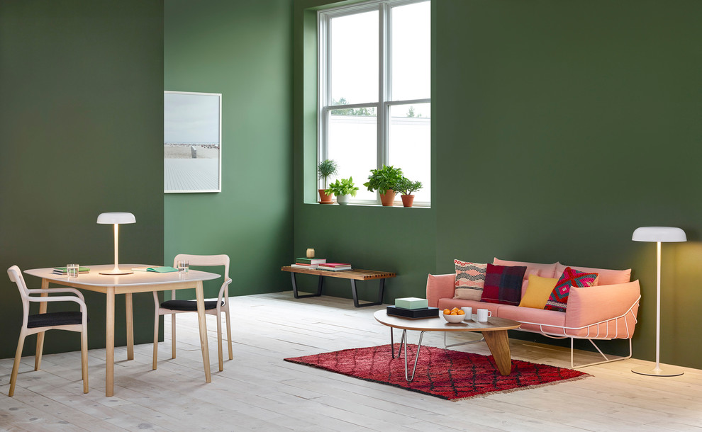На фото: гостиная комната в стиле модернизм с зелеными стенами и деревянным полом с