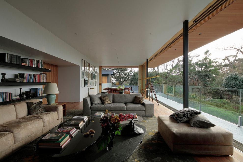 Photo of a contemporary open plan living room in Other with white walls, medium hardwood flooring and brown floors.