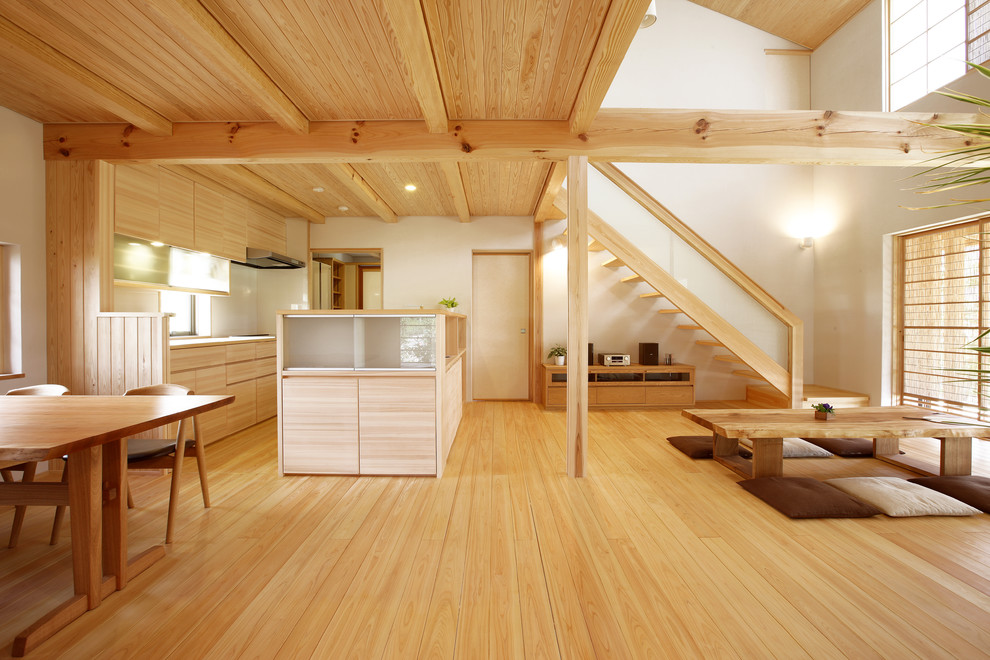 Offenes Asiatisches Wohnzimmer mit weißer Wandfarbe, braunem Holzboden und braunem Boden in Sonstige