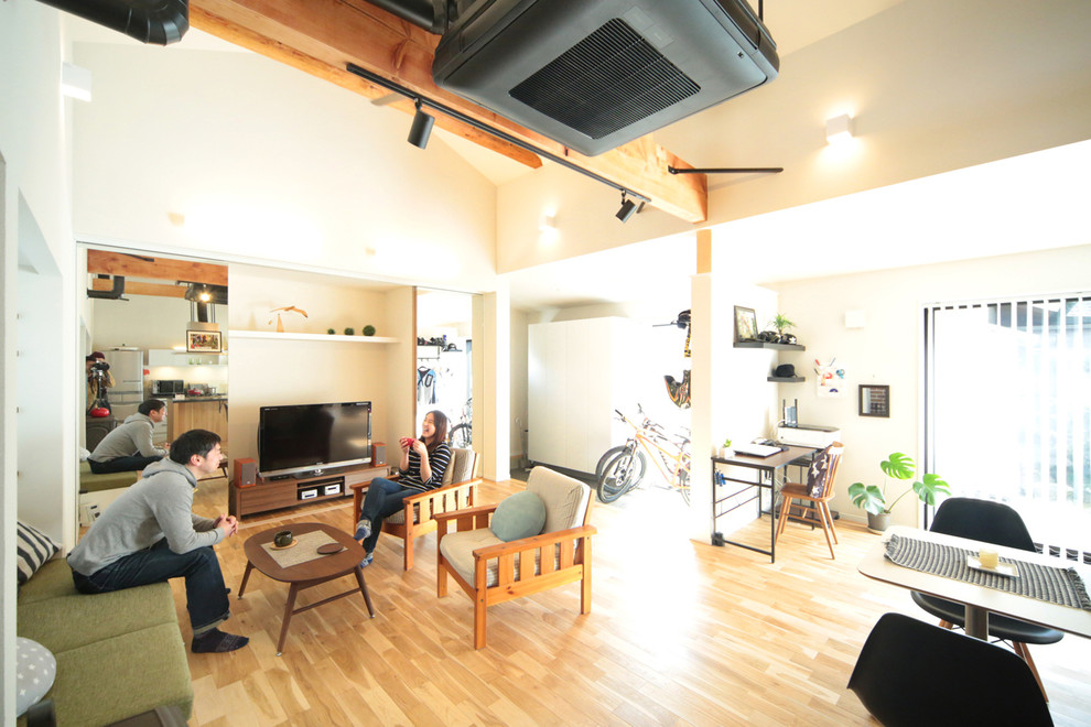 Cette photo montre un salon scandinave ouvert avec un mur blanc, un sol en bois brun et un téléviseur indépendant.