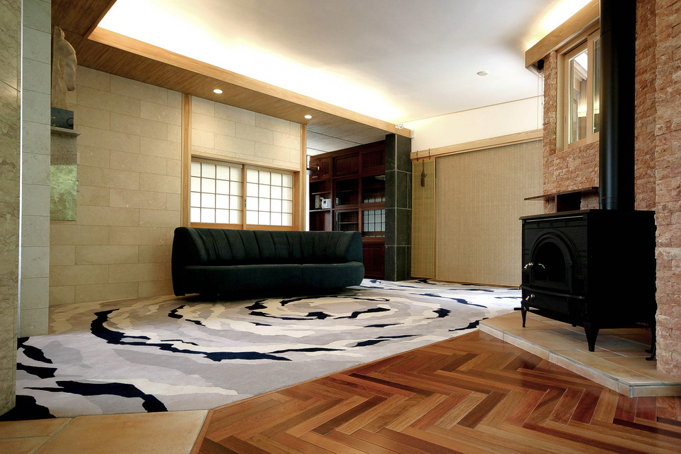 Пример оригинального дизайна: огромная парадная гостиная комната в восточном стиле с белыми стенами, татами, печью-буржуйкой, фасадом камина из камня, отдельно стоящим телевизором и разноцветным полом