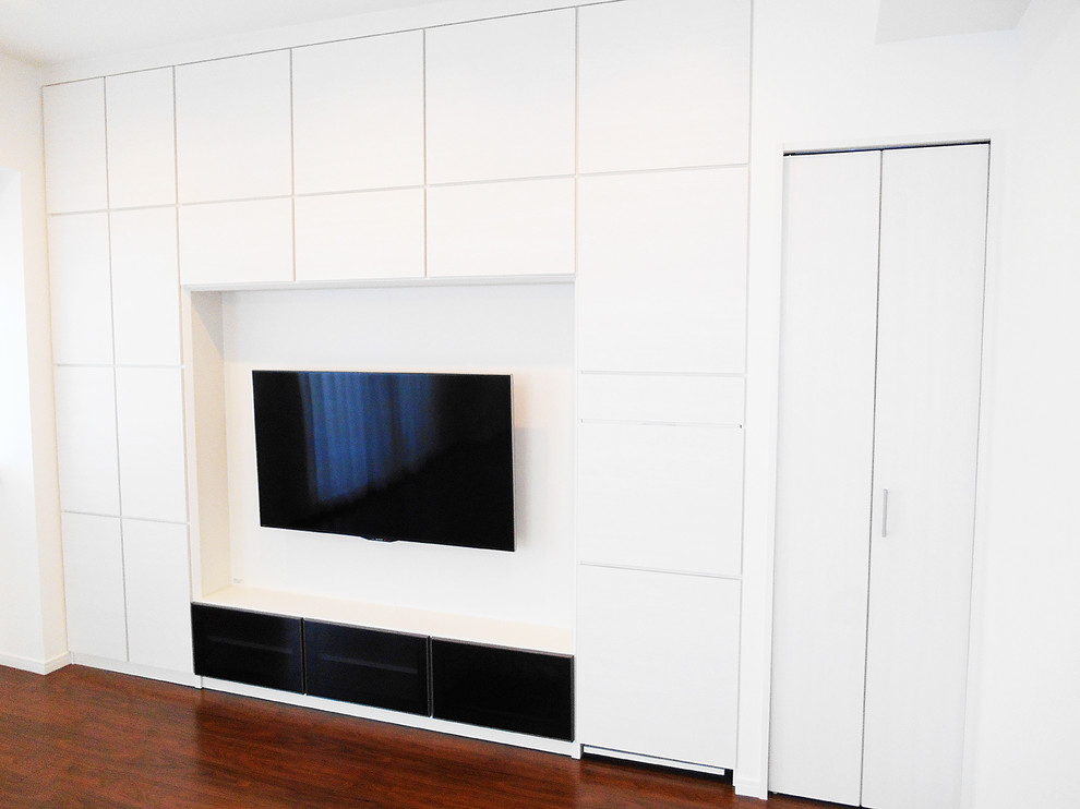 Cette image montre un salon style shabby chic ouvert avec un mur blanc, parquet foncé, un téléviseur fixé au mur et un sol marron.
