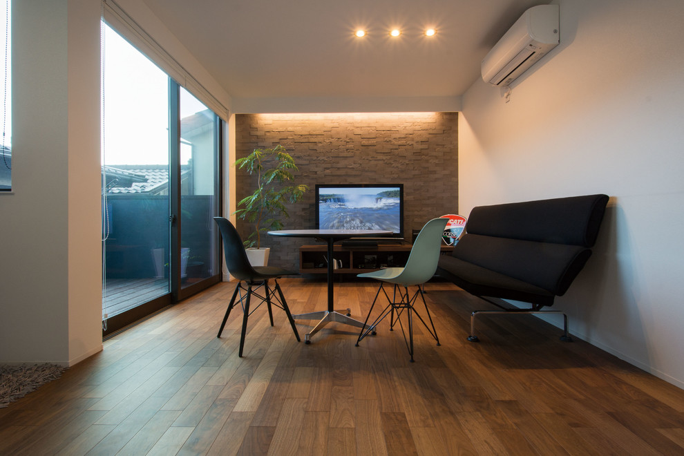 Esempio di un soggiorno minimal aperto con pavimento in compensato e TV autoportante