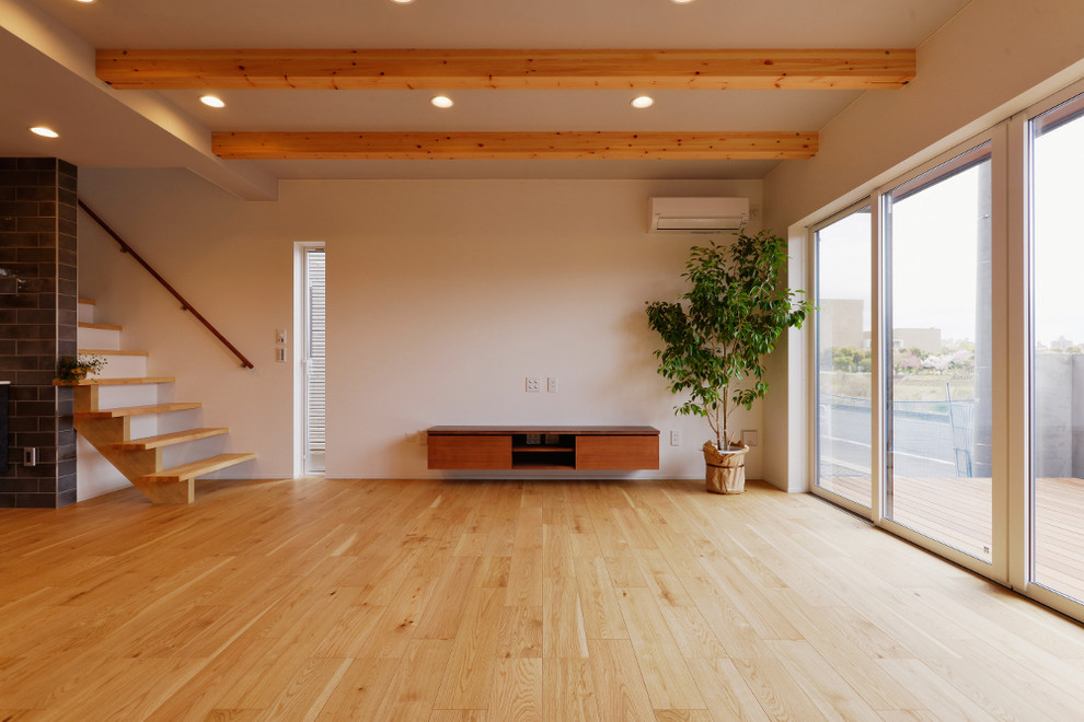 This is an example of a modern open plan living room in Tokyo Suburbs with a wall mounted tv.