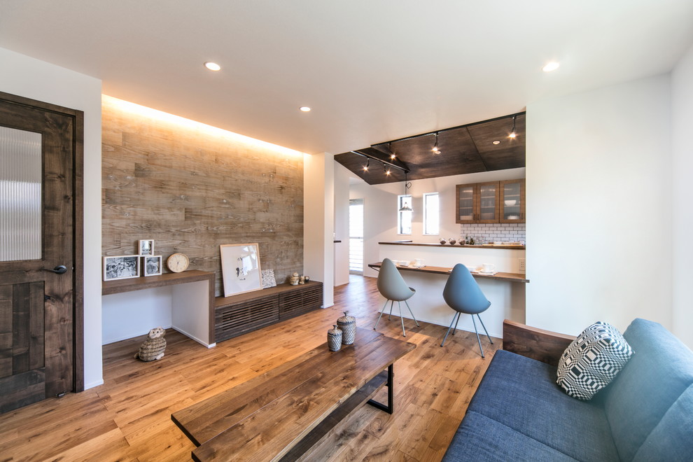 Стильный дизайн: открытая гостиная комната в скандинавском стиле с белыми стенами, паркетным полом среднего тона и коричневым полом - последний тренд