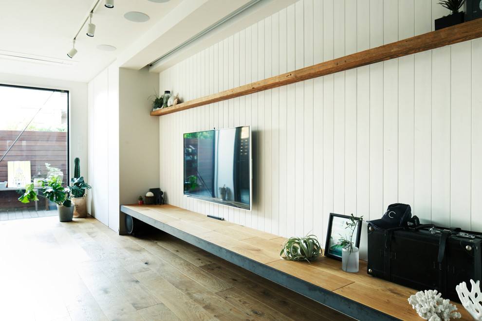 Immagine di un soggiorno rustico di medie dimensioni e aperto con pareti bianche, pavimento in legno massello medio, nessun camino e TV a parete