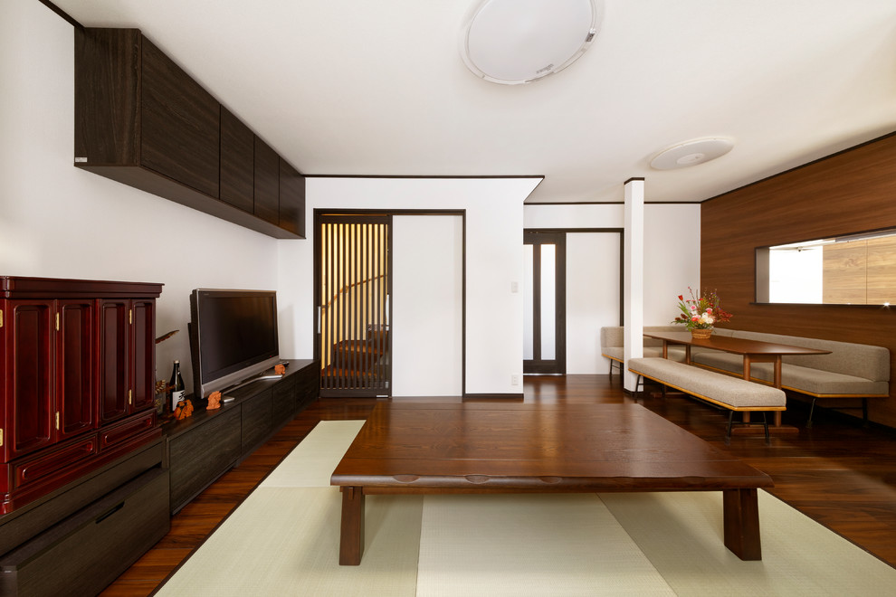 Cette image montre un salon asiatique fermé avec un mur blanc, parquet foncé et un téléviseur indépendant.