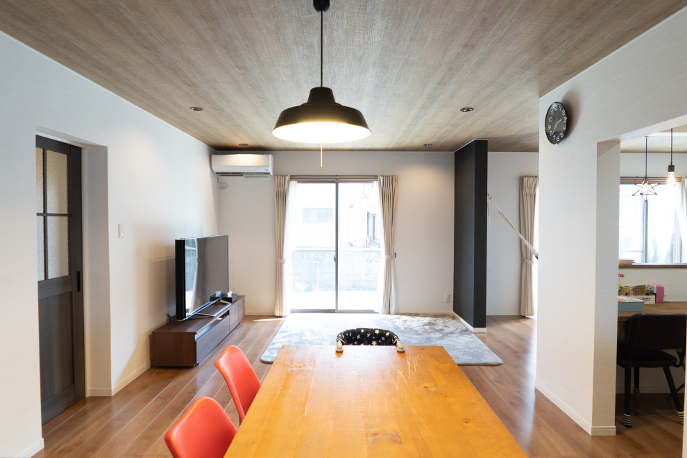 Foto de salón abierto actual grande sin chimenea con paredes blancas, suelo de madera en tonos medios, televisor independiente y suelo marrón