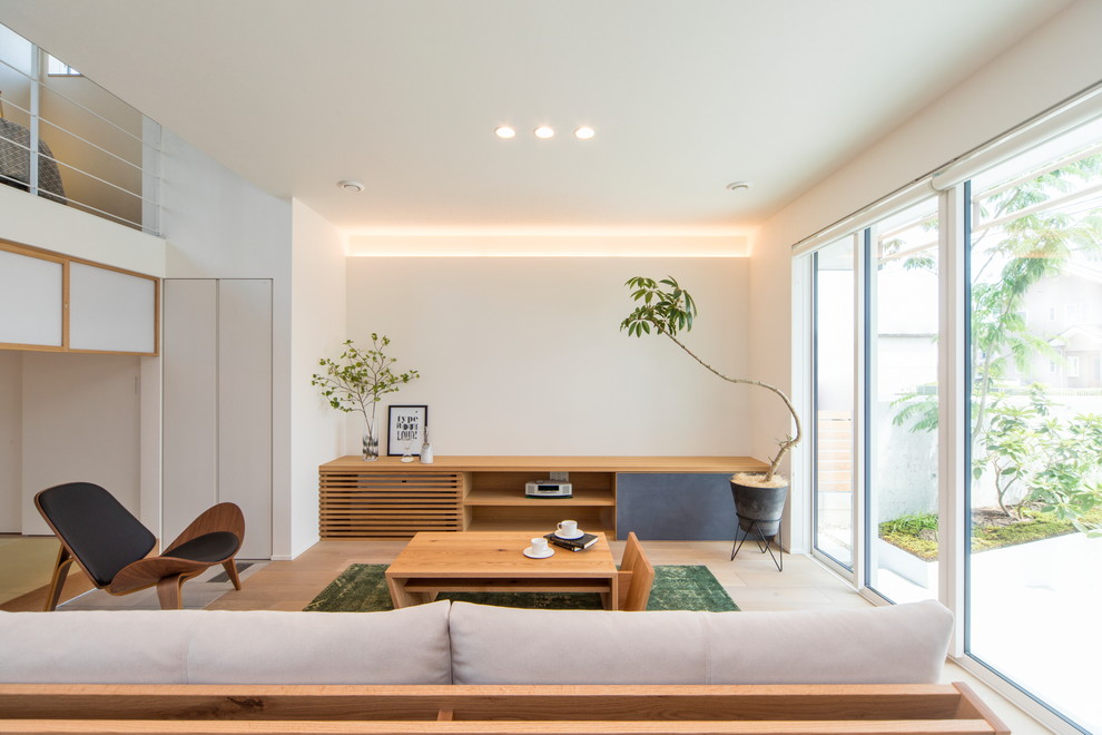 Inspiration för ett skandinaviskt vardagsrum, med vita väggar, ljust trägolv och brunt golv