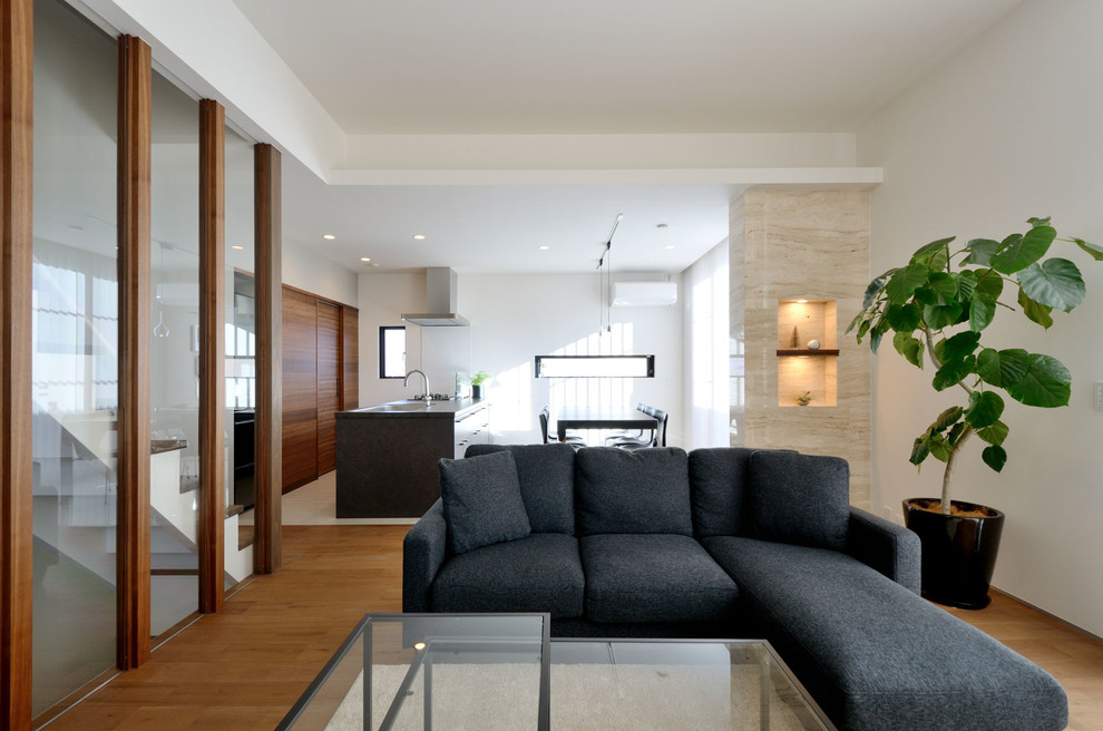 Example of an asian open concept medium tone wood floor and brown floor living room design in Tokyo Suburbs with white walls