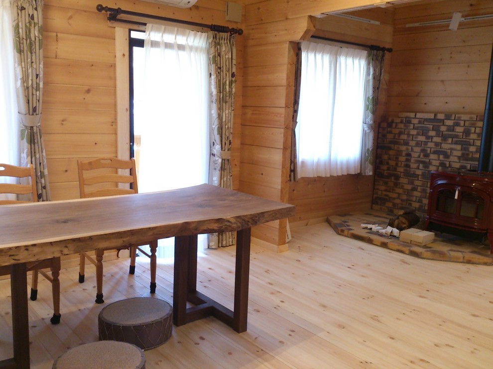 Ispirazione per un soggiorno scandinavo aperto con stufa a legna, cornice del camino in mattoni e parquet chiaro