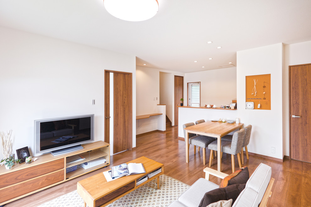 Ispirazione per un soggiorno minimal con pareti bianche, pavimento in legno massello medio e pavimento marrone