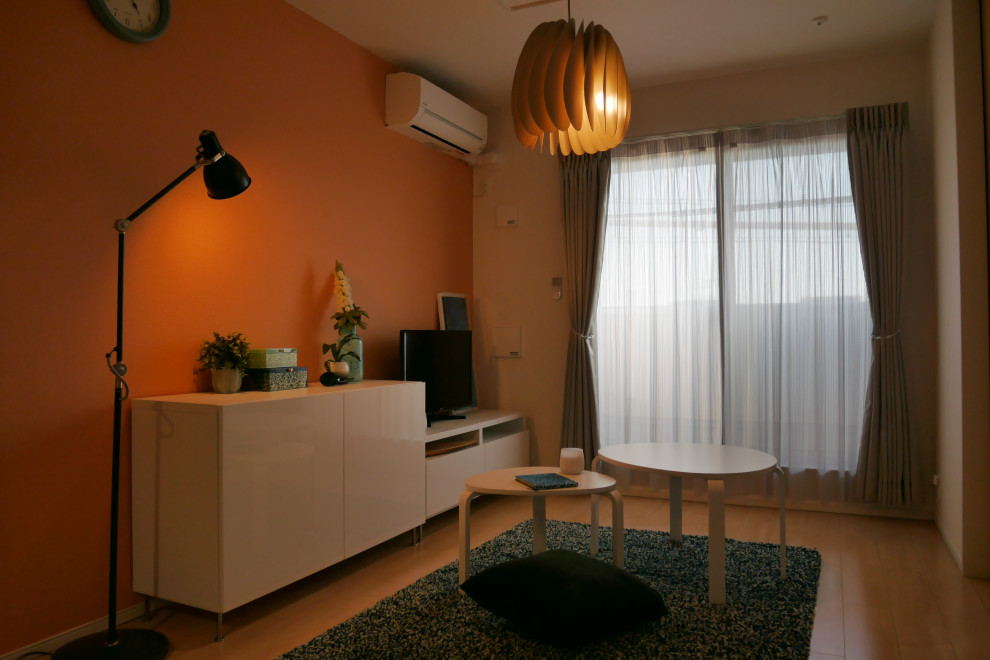 На фото: маленькая открытая гостиная комната в скандинавском стиле с оранжевыми стенами, полом из фанеры и отдельно стоящим телевизором для на участке и в саду с